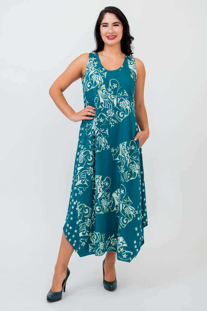 Woman wearing teal sleeveless tank dress with white floral pattern and asymmetric hem