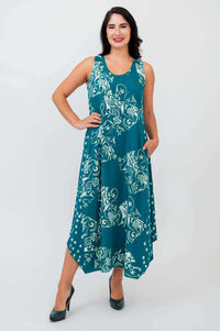 Woman wearing teal sleeveless tank dress with white floral pattern and asymmetric hem