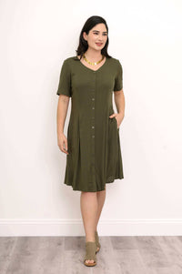 Woman in olive dress styled with gold necklace, button-front and tie-back detail