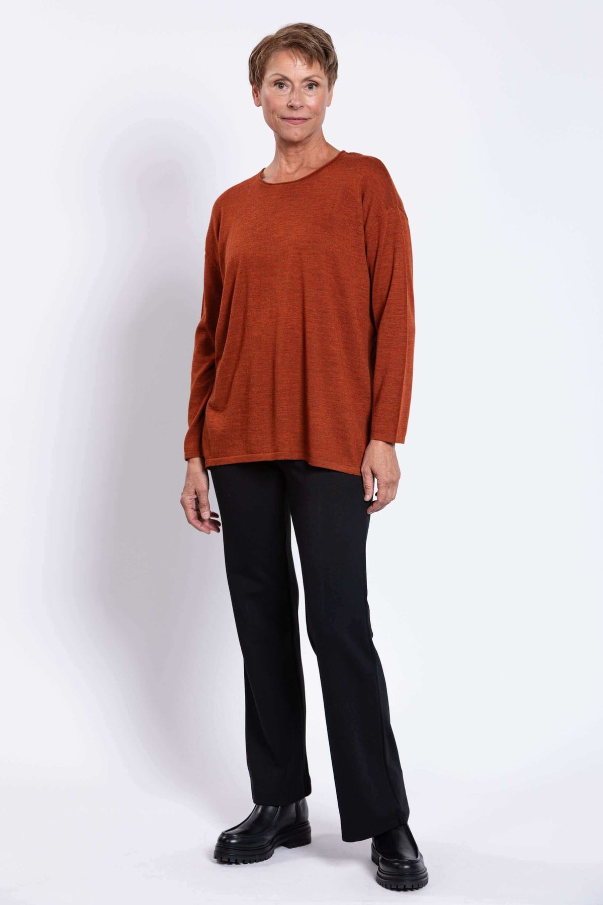 Three-quarter front view of a woman modeling a relaxed merino wool sweater