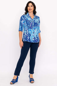 Three-quarter front view of a woman in a button-up blue blouse and navy pants