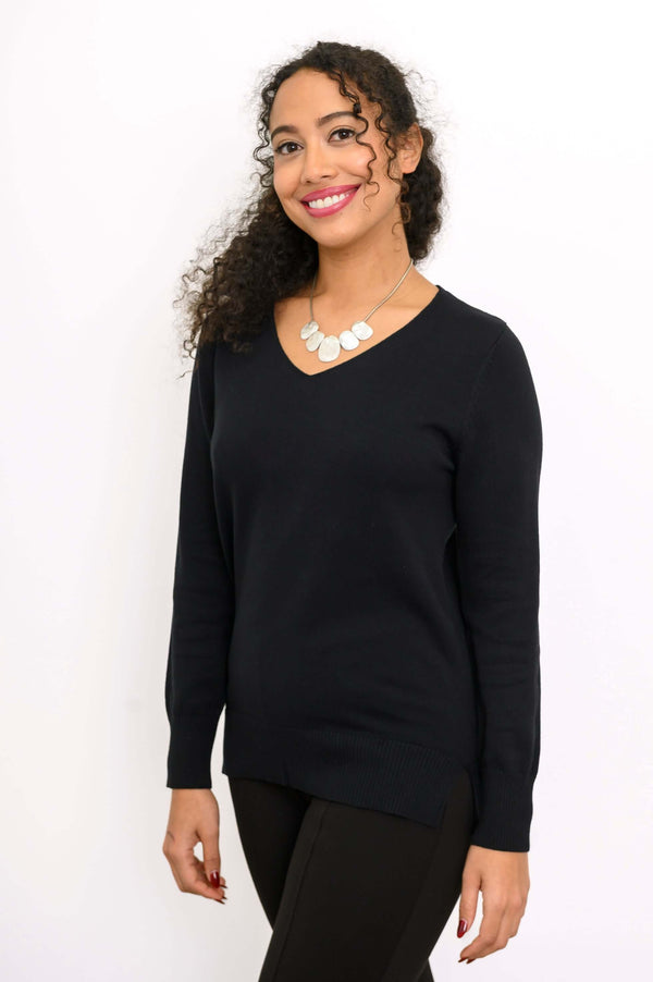 Three-quarter front view of woman wearing a black V-neck sweater and black pants