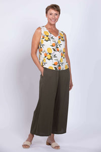 Three-quarter pose of woman in sleeveless lemon print tank top with pockets