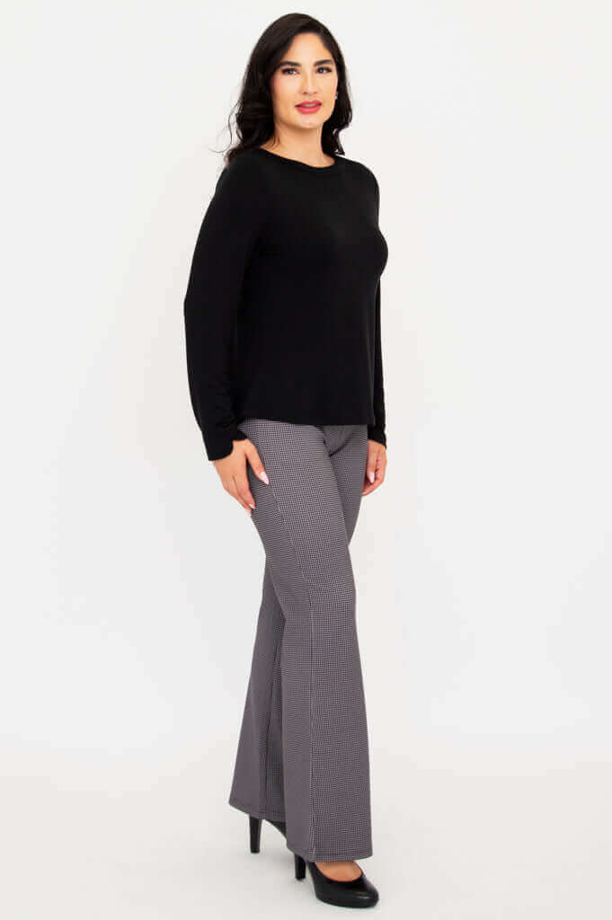 Three-quarter side view of woman in Mona boat neck French Terry top and check pants
