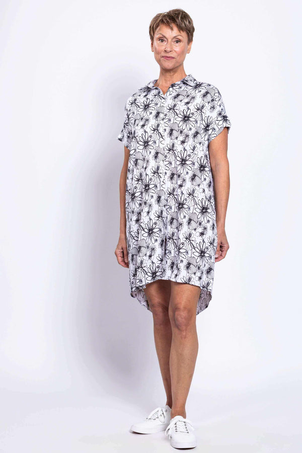 Three-quarter view of a woman in high-low hem and floral print dress