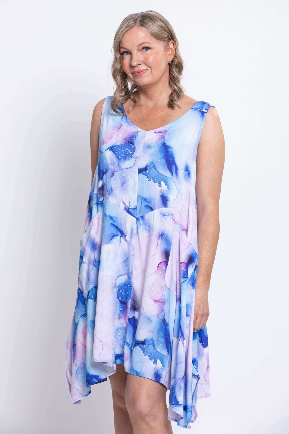 Three-quarter view of woman in blue and purple watercolor print dress