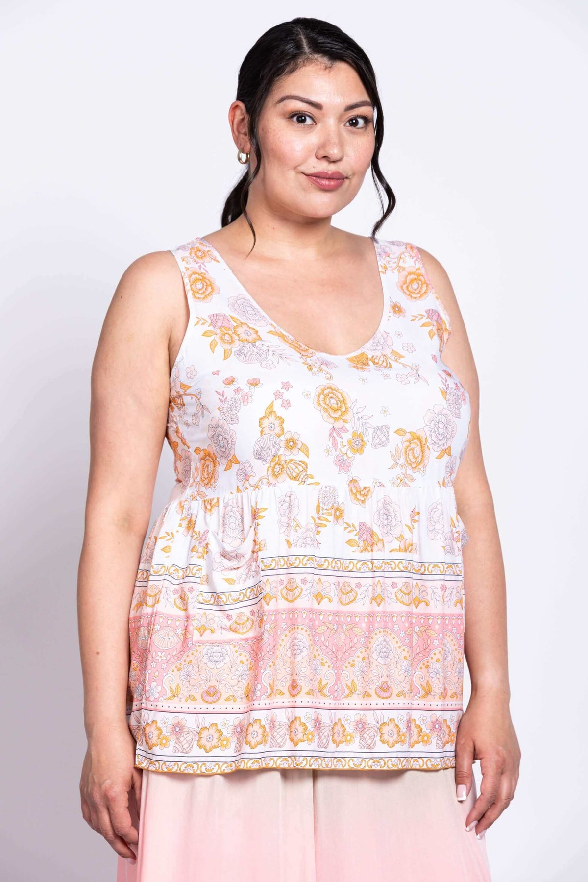 Three-quarter view of model in white floral Kaya Tank Top and light pink skirt