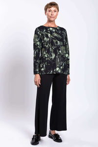 Three-quarter view of Margie printed boat neck top paired with black trousers