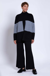 Three-quarter view of woman modeling black and grey colour-block open front sweater