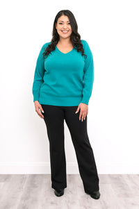 Hip length teal blue pullover sweater with ribbed cuffs and hem, worn for a casual everyday outfit.
