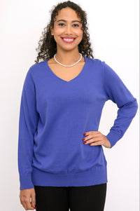 Close up front view of a woman wearing a violet blue v-neck knit sweater paired with black trousers.