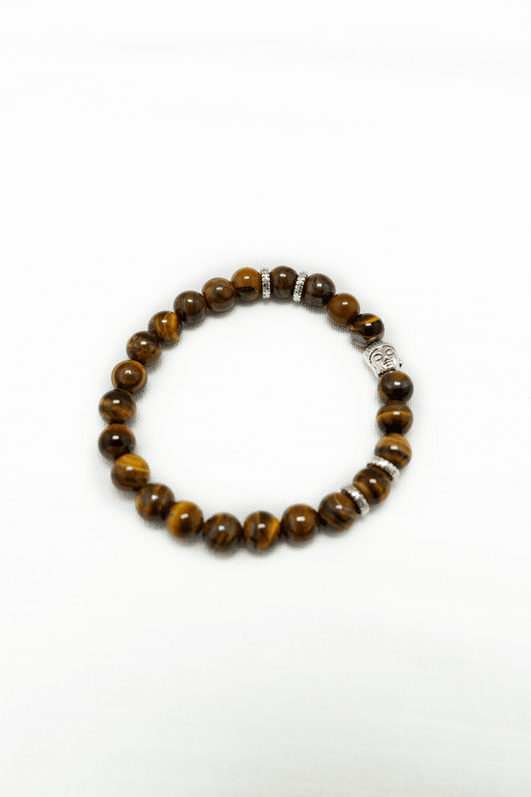 Tiger eye beaded bracelet with silver Buddha charm and spacers on a white background