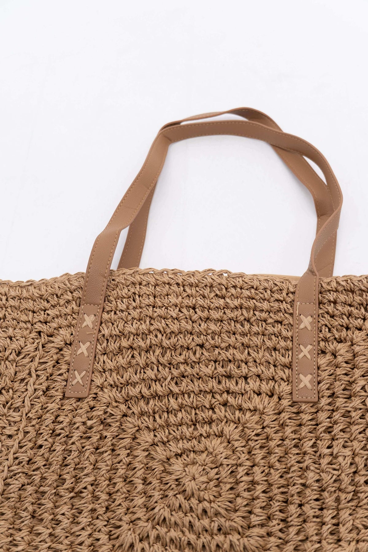 Top view of woven paper tote bag showing dual tan handles and stitching details
