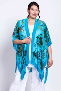 Model wearing a turquoise kimono wrap with floral designs, shown front and cropped