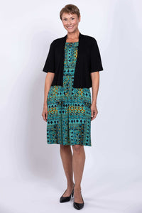 Woman in turquoise mosaic dress with black short-sleeve cover-up, front view