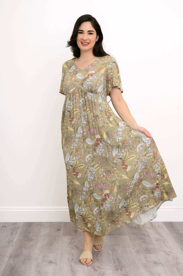 Woman twirling in green floral Jane empire waist maxi dress