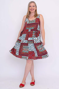 Woman twirling in colorful patchwork sleeveless summer dress