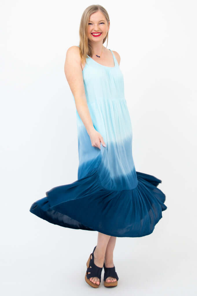 Woman twirling in a flowy blue ombre maxi dress showing dress movement