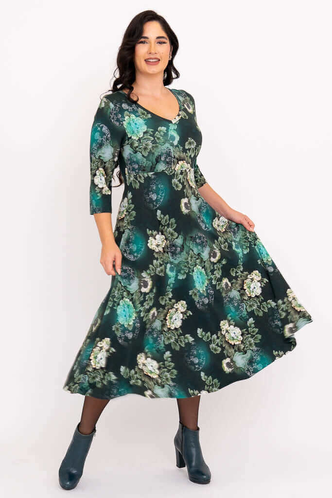 Model twirling in a jade green floral midi dress showing the flowy A-line skirt