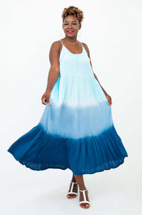 Woman twirling in a blue ombre maxi dress with a tiered hem