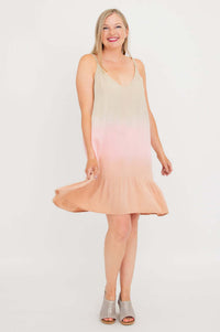 Woman twirling in sleeveless ombre dress with adjustable straps and flounce hem