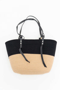 Top view of a black and beige two-tone cotton tote bag with black leather handles