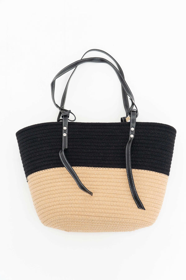 Top view of a black and beige two-tone cotton tote bag with black leather handles