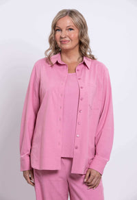 Woman in a pink linen shirt with breast pocket, front view upper body and hand in pocket