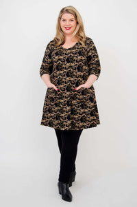 Model displaying Veronica Tunic in black vine print, hands in patch pockets