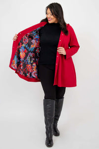 Person showing the vibrant colorful lining inside the berry red swing coat