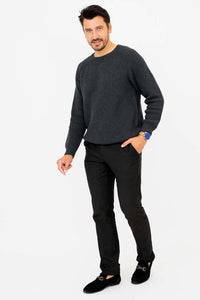 Man walking in charcoal sweater and black pants with a smile