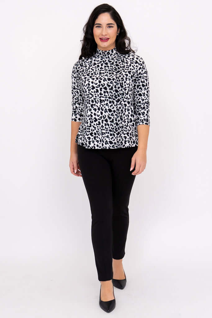 Woman walking forward in leopard print top and black pants