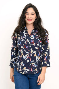 front view of woman wearing navy blue blouse with multicolor floral print on a white background