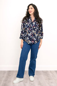 front view of woman wearing navy blue blouse with multicolor floral print on a white background