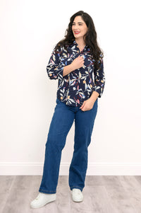 front view of woman wearing navy blue blouse with multicolor floral print on a white background