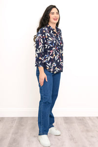 side view of woman wearing navy blue blouse with multicolor floral print on a white background