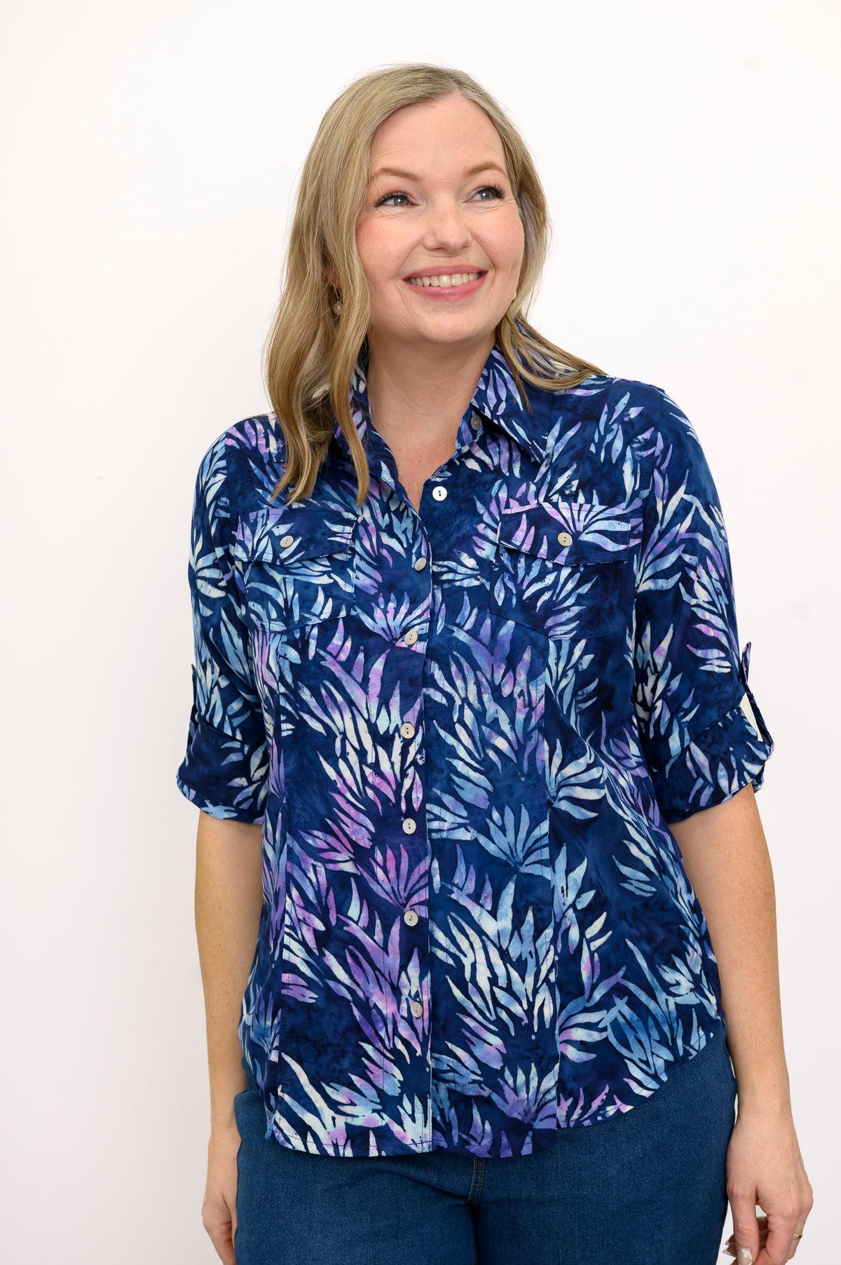 Front view of woman wearing a blue floral patterned blouse and jeans