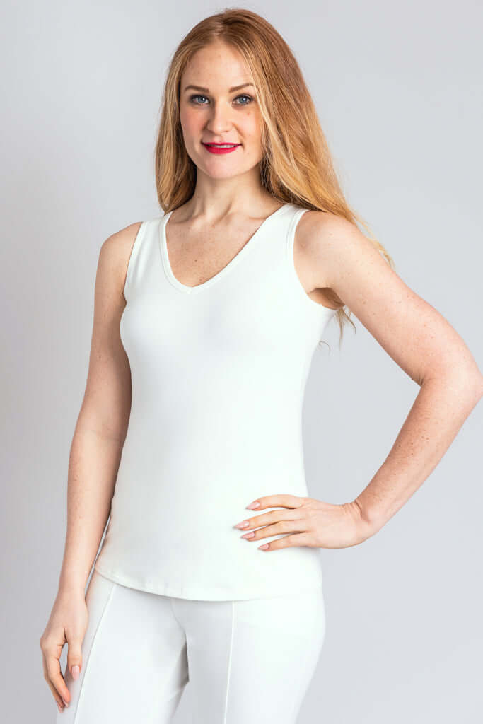 Woman modeling white bamboo tank, V-neck, hand on hip, angled front view