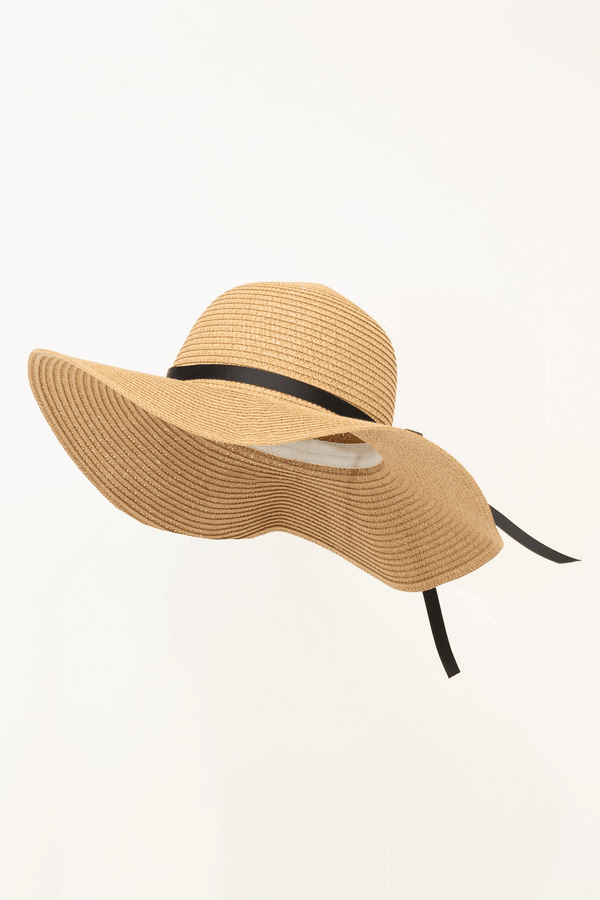 Wide brim straw floppy hat with black ribbon, side angle
