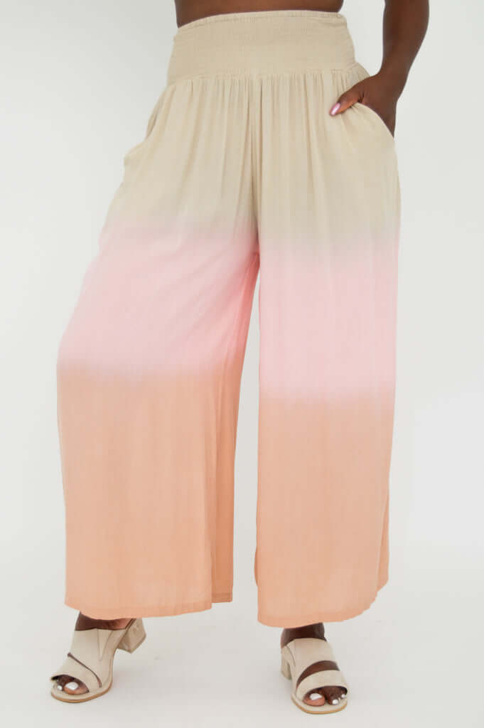 Wide leg ombre pants in beige and peach with hand in pocket