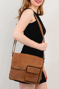 Woman wearing a brown buffalo leather messenger bag over the shoulder