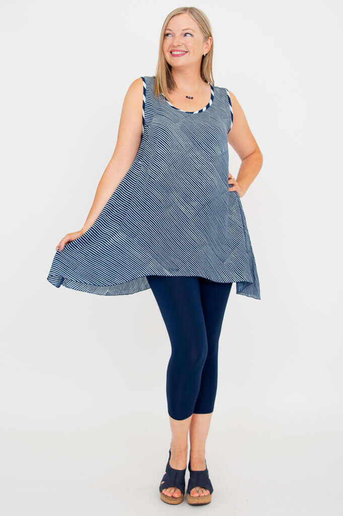 Woman modeling the navy stripe swing tank, showing its flowing A-line shape