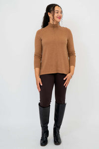 Woman facing forward in camel sweater and knee-high boots