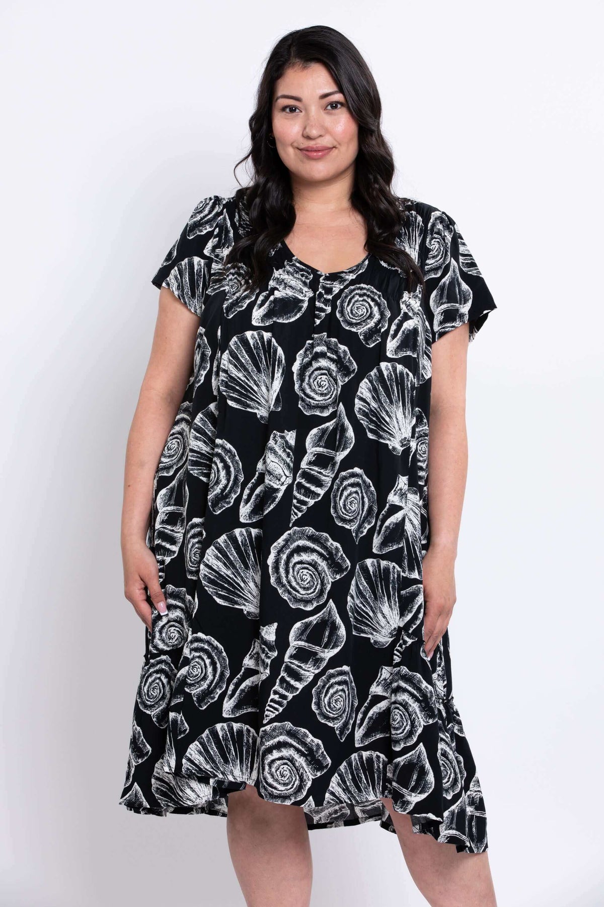 Woman wearing a Noosa shell dress facing slightly to her left