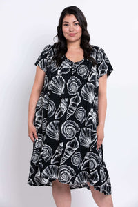 Woman wearing a Noosa shell dress facing slightly to her left
