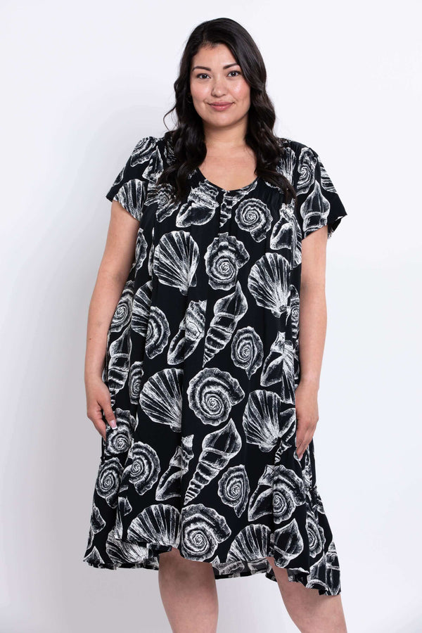 Woman wearing a Noosa shell dress facing slightly to her left