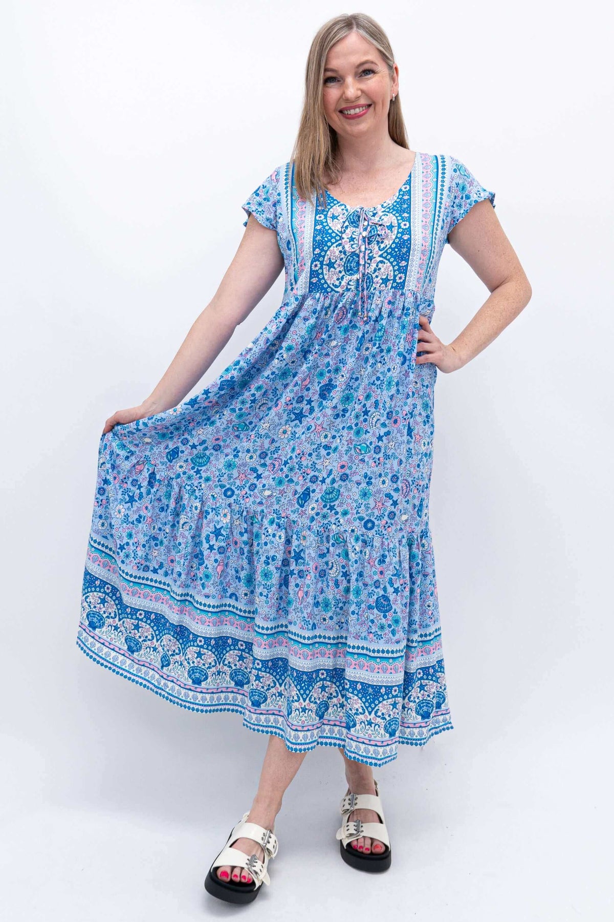 Woman holding out the tiered skirt of the blue Sharpie Dress