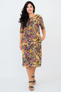 Woman smiling in Olivia dress in Tropikal print, showing relaxed front pose