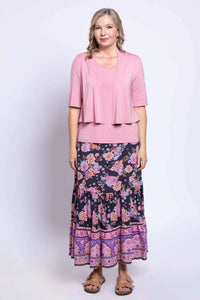 Woman in Tibby floral skirt, pink top, and matching short sleeve cardigan
