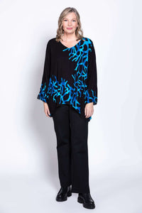 Woman in a black top with vibrant blue coral pattern, full view, standing